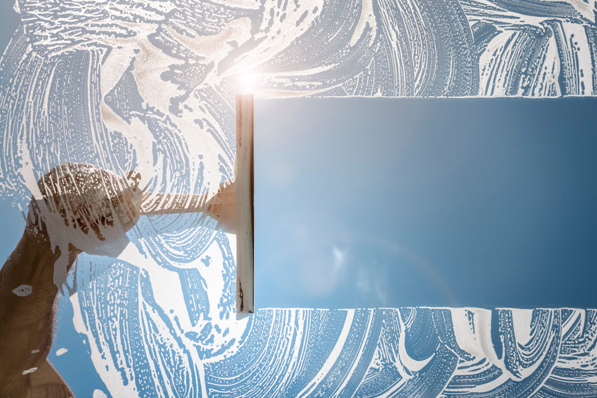 Worker applying blue and white decorative paint or coating to a wall surface